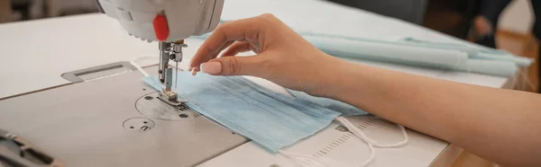 Ausgeschnittene Ansicht der Näherin, die medizinische Maske im Atelier näht, Banner — Stockfoto