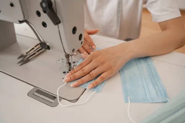 Vue recadrée du masque médical de couture de couturière floue en atelier — Photo de stock