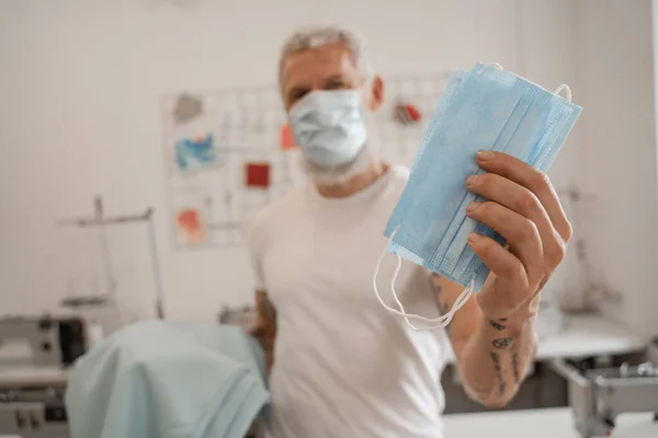 Sarto sfocato con maschere mediche in atelier — Foto stock