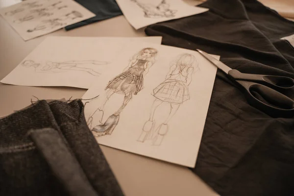Cloth and sketches on table in designer studio — Stock Photo