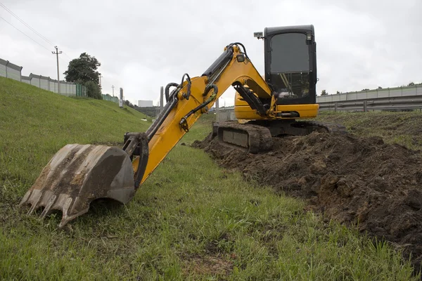 Escavatore giallo in un cantiere — Foto Stock