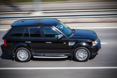 Siyah Range Rover, hızlı bir şekilde yolda gidiyor