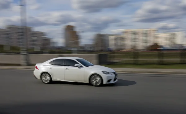 Krásné bílé auto jezdí po městě — Stock fotografie