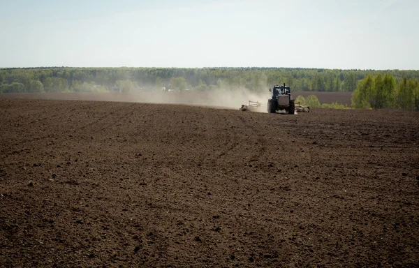 Traktor auf gepflügtem Feld — Stockfoto