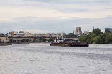 Nehrin üzerinde ağır bir mavna iterek römorkör