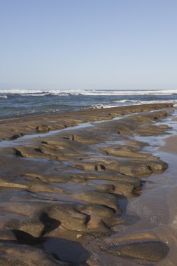 Mavi gökyüzü, mavi deniz ve kayalar.