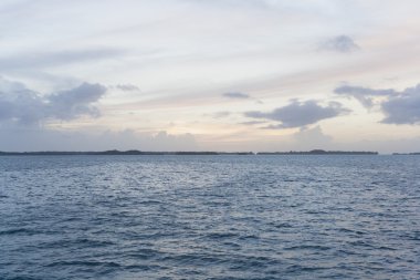 Mavi gökyüzü, mavi deniz ve yeşil Adaları günbatımı üzerinde