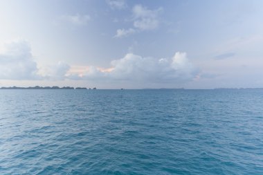Mavi gökyüzü, mavi deniz ve yeşil Adaları günbatımı üzerinde