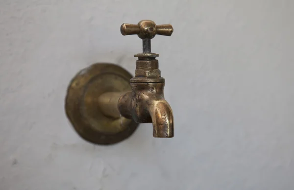 Torneira de cobre antiga em uma parede — Fotografia de Stock