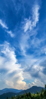 Bulutları ve mavi gökyüzü olan güzel bir manzara.