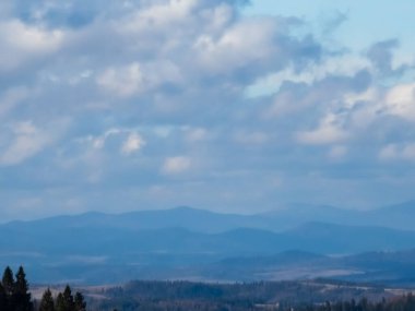 Güzel bir dağ manzarası ve bulutlu bir gökyüzü.