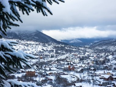 Arkasında karlı ağaçlar olan bir dağ köyü manzarası