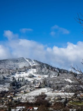 Köyün ortasında karla kaplı bir kış manzarası..