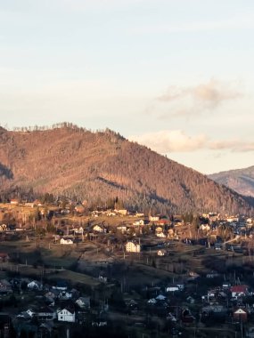 Akşam ışığında dağların köyü olan bir tepeden manzara.