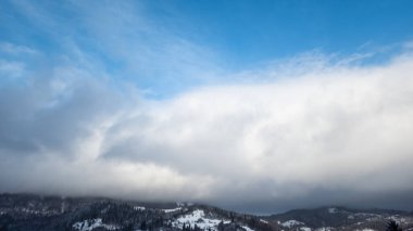 Bulutlu kış dağı ve mavi gökyüzü