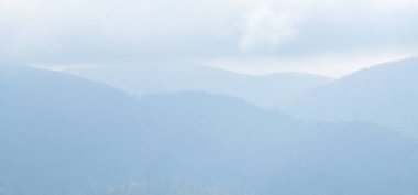 Dağları ve mavi gökyüzü olan güzel bir manzara.