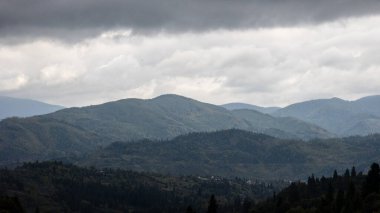 Bulutlu ve gökyüzü olan dağ manzarası
