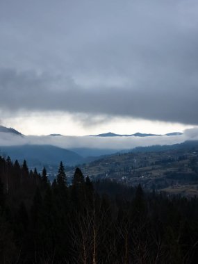 Güneş dağlardaki bulutların arkasında.