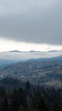 Dağları ve bulutlu gökyüzü olan güzel bir manzara.