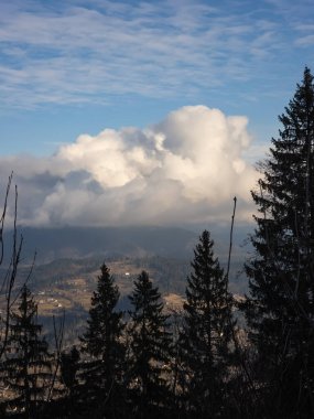 Bulutlu bir gökyüzünün altında bulutlu bir gün ile kaplı bir dağ sırasının alçak açılı çekimi.