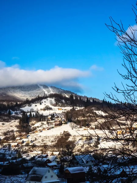 Bulutlu bir gökyüzü ve küçük bir kasaba olan güzel bir dağ manzarası.