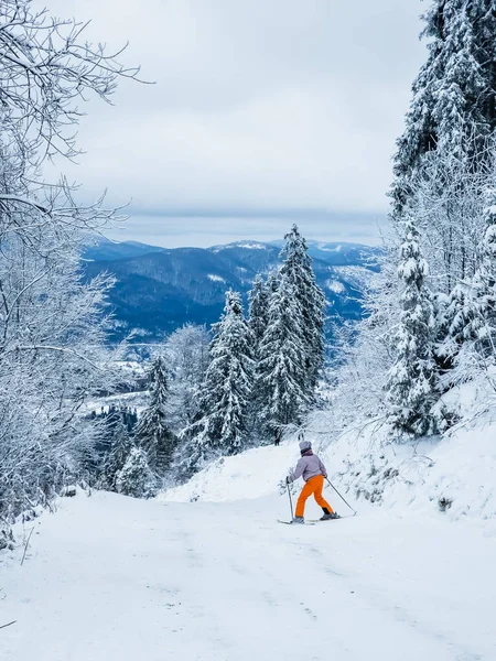 Ormanda yürüyen kar ayakkabılı ve sırt çantalı genç adam.