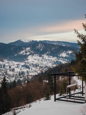 Dağlarla kaplı kar ve ahşap bir evle güzel bir kış manzarası.