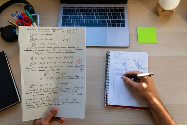 top view of high school or college student studying and doing exercises on a desk with a laptop