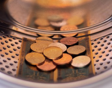 para aklama konsepti - kripto bitcoin paraları ve çamaşır makinesindeki faturalar