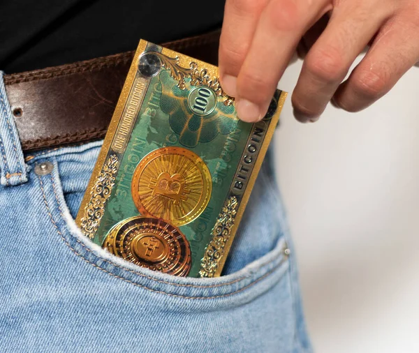 Kripto Bitcoin faturasını cebine koyan adam, kripto para işi, mali geçmiş, yatırım ve tasarruf konsepti fotoğrafı