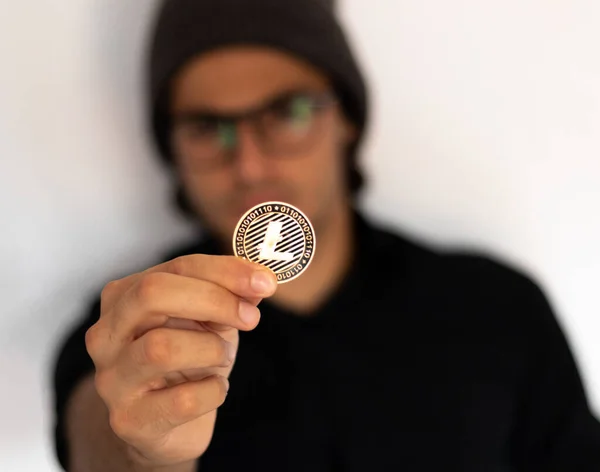 Şapkalı ve gözlüklü adam kripto litekoin adamını düşünüyor ve düşünüyor, kripto para birimini, yatırımı ve tasarruf konsepti fotoğrafını temsil ediyor.