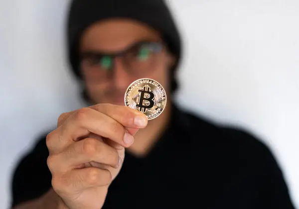 Şapkalı ve gözlüklü bir adam şifreli para birimini, yatırımı ve tasarruf konseptini temsil eden şifreli para adamını düşünüyor ve düşünüyor.