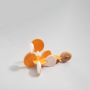 Dilimlenmiş tereyağlı kabak ve gri arkaplanda izole edilmiş beyaz turptan oluşan soyut kompozisyon.