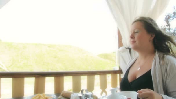 Frau trinkt Tee im Café: Zeitlupe. Mit Schieberegler gefilmt — Stockvideo