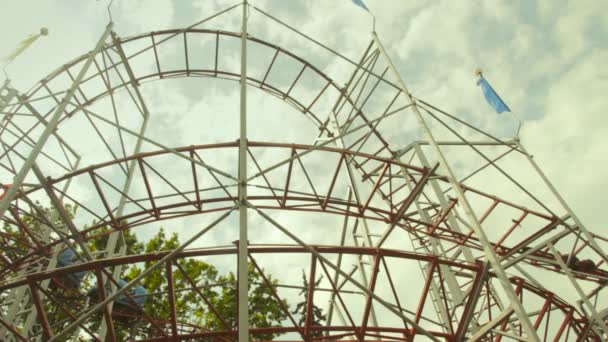 La gente monta en una montaña rusa en el parque — Vídeos de Stock