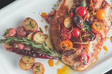 Sebzelerle demir bir tavada pişmiş balık.