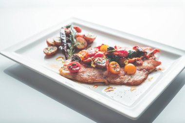 Sebzelerle demir bir tavada pişmiş balık.