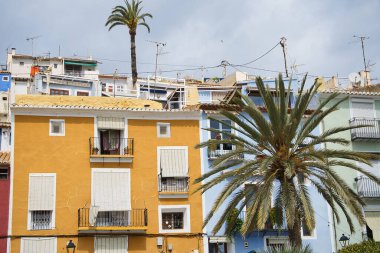 İspanya 'nın Alicante kentindeki Villajoyosa kasabasında bulunan bazı palmiye ağaçları olan eski renkli binaların manzarası
