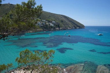 Moraira 'nın berrak sularının panoramik manzarası, Akdeniz Alicante İspanya' sındaki El Portet plajı.