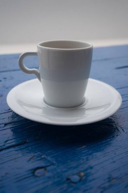 Mavi arka planda beyaz kahve fincanı.