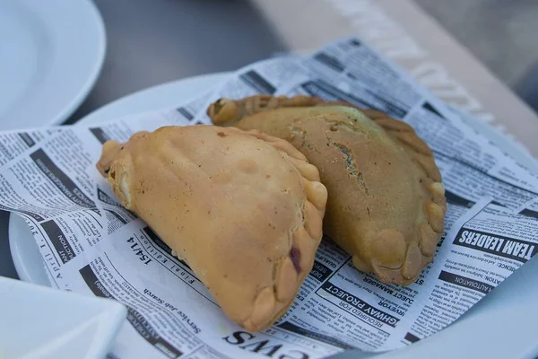 Zwei Argentinische Empanadas Serviert Auf Einem Teller Über Zeitungsausschnitten — Stockfoto