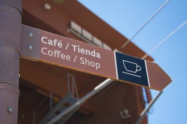 Kahveyi ve dükkanı işaret eden yatay tabela genellikle halka açık bir alanda, müzede, tiyatroda, plajda, lunaparkta, oyunlarda ve sokakta bulunur..