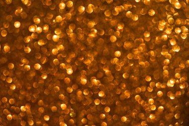 Parlak altın dokusunda soyut ve odaklanmamış bir arkaplan. Etkinlikler ve kutlamalar için ideal parfüm ve mücevher.