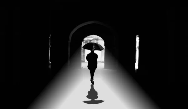 Zdjęcia Młodej Dziewczyny Chodzącej Parasolem Przez Alejkę Światłem Dochodzącym Niej — Zdjęcie stockowe