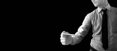 İyi giyimli bir çalışanın elinde siyah arka planda izole edilmiş bir akıllı telefon tutarken görüntüsü..