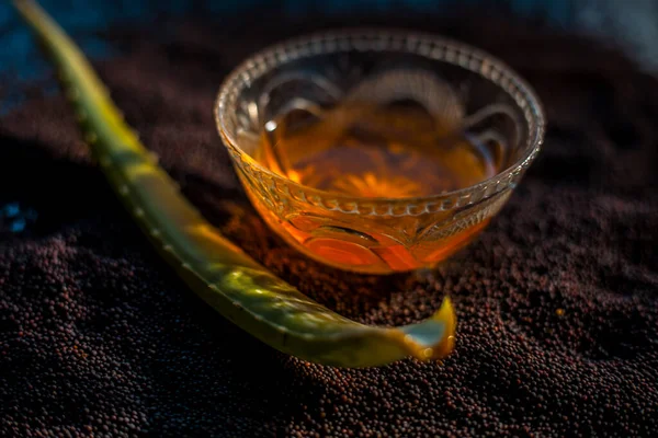 Parlayan deri için hardal tohumu maskesi. Hardal tohumu, aloe vera ve siyah bir yüzey üzerinde cam bir kasede biraz bal içeren yüz maskesi malzemeleri..