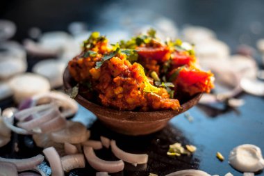 Sukhi bhaji ya da Jeera Aloo 'yu kilden bir kaseyle yakın plan çek. Biraz da soğan halkası..