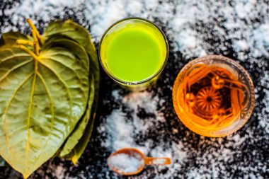 Betel yapraklarından oluşan yağlılığı kontrol etmek için yüz maskesi siyah ahşap bir yüzeyde meyve suyu, bal ve deniz tuzu..