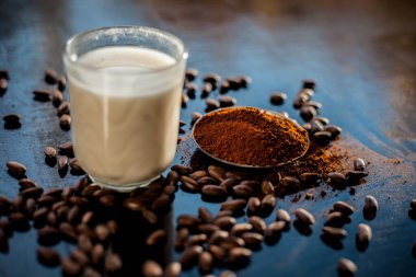 Yüz maskesi kahve tozu ve süt içerir siyah renkli yüzeyde doğal olarak parlayan cilt için..