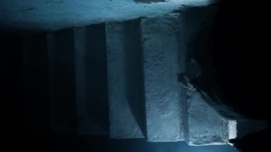 Bir kadının alt kattan dramatik ışıklandırmayla gelen dumanla alt katta yürüdüğü en iyi sinematik çekim..